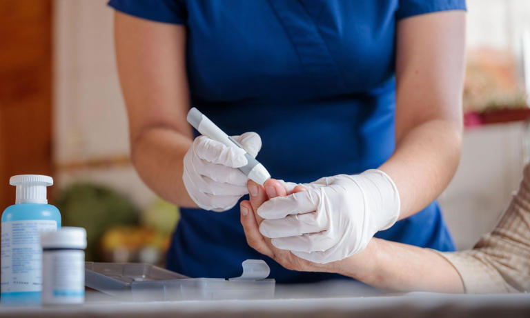 A picture of a nurse testing a patient for diabetes.