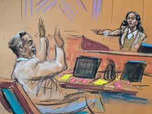 Sean "Diddy" Combs raises his hands as he is pointed out by Dawn Richard during Combs's sex trafficking trial Friday in New York City. (Jane Rosenberg/Reuters)