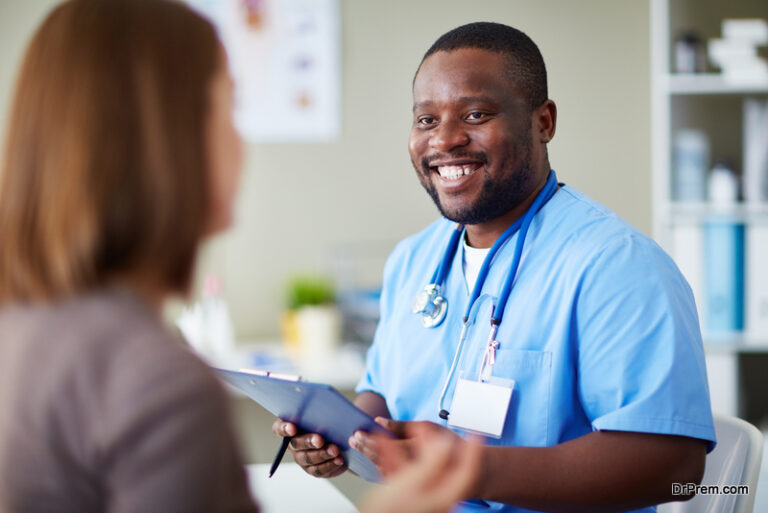 Smiling African doctor working with patient in his office