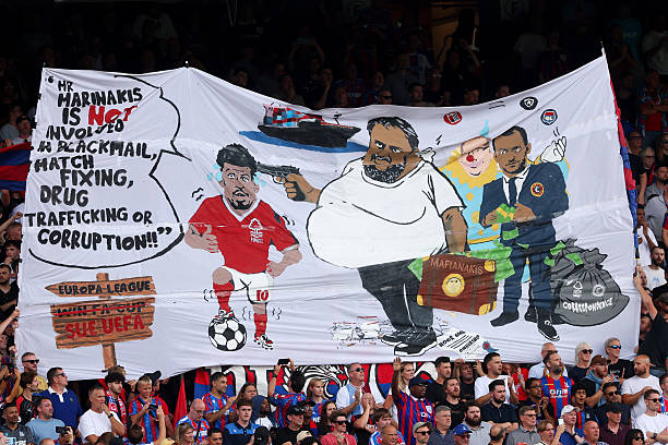 FA investigating Palace banner showing Forest owner Marinakis with gun to Gibbs-White’s head, as Forest condemn it as inflammatory and xenophobic.