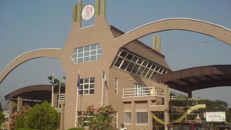 University of Benin entrance gate with students walking past ahead of second-semester examinations.