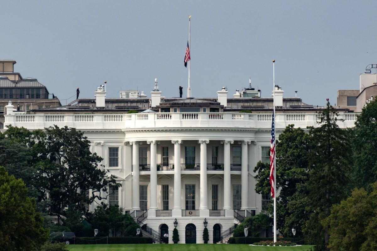 National Guard troops and police officers stand behind yellow tape after a shooting incident close to the White House.